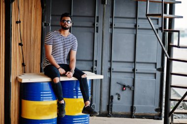 Yakışıklı uzun boylu Arap sakal man modeli soyulmuş gömlek, açık poz verdi. Güneş gözlüğü moda Arap adama.