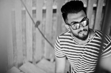 Yakışıklı uzun boylu Arap sakal man modeli soyulmuş gömlek, açık poz verdi. Güneş gözlüğü moda Arap adama.