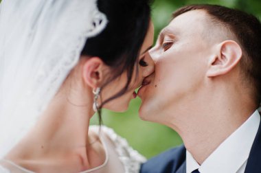 Yakın çekim fotoğraf oturan ve parkta öpüşme düğün çift. 