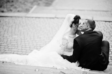 Yakın çekim fotoğraf oturan ve parkta öpüşme düğün çift. Siyah ve beyaz fotoğraf.