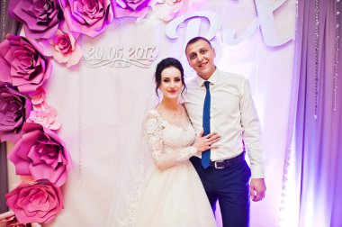 Restoran dekore edilmiş duvarda poz güzel düğün çifti.