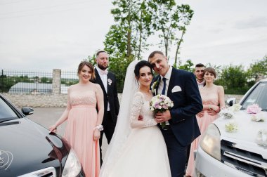 Düğün çifti ve sağdıçlar iki dekore düğün otomobil arasında poz nedime ile.