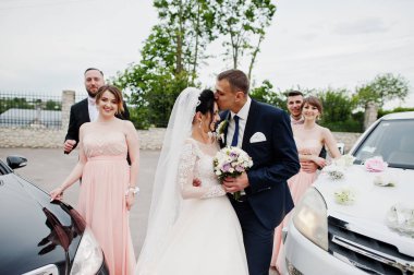 Düğün çifti ve sağdıçlar iki dekore düğün otomobil arasında poz nedime ile.