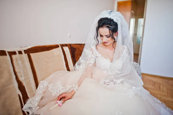 室内のソファーの上に座って美しい白いウェディング ドレスの花嫁の肖像画 — ストック写真