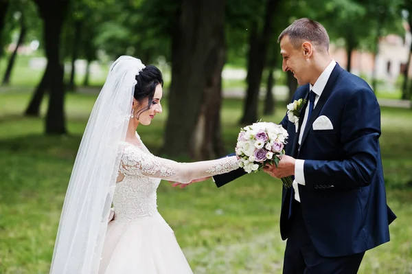 Upea Onnellinen Aviopari Seisoo Vihreässä Puistossa Hääpäivänään — kuvapankkivalokuva