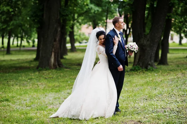 Nádherný Šťastný Novomanželský Pár Stojící Zeleném Parku Jejich Svatební Den — Stock fotografie