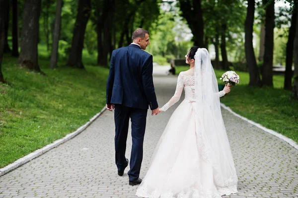 結婚式のカップルを歩くと美しい日に公園で楽しんで — ストック写真