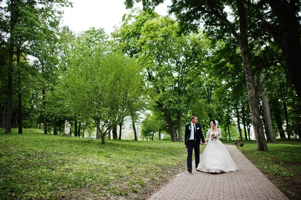 結婚式のカップルを歩くと美しい日に公園で楽しんで — ストック写真