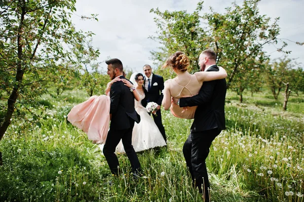 結婚式のカップルの立っていると回転して自分たちの手でブライドメイド花婿付け添人を見て — ストック写真