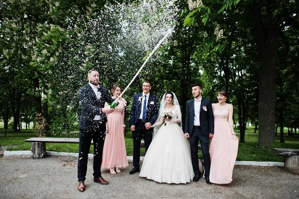 Грумсмен Открывает Бутылку Шампанского Парке Свадебной Парой Подружками Шафером Наготове — стоковое фото