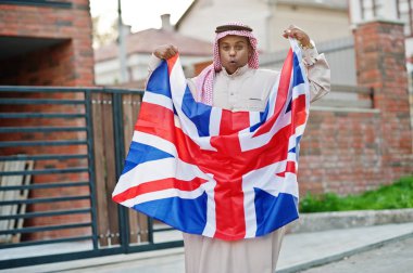 Orta Doğu Arap adam sokakta Büyük Britanya bayrağı ile poz verdi. İngiltere ve Arap ülkeleri kavramı.