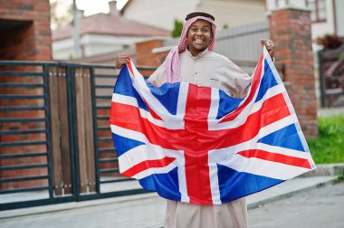 Orta Doğu Arap adam sokakta Büyük Britanya bayrağı ile poz verdi. İngiltere ve Arap ülkeleri kavramı.