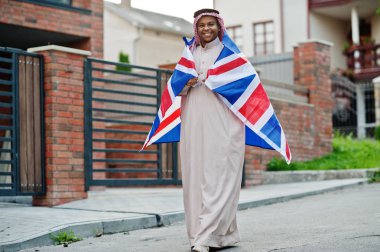 Orta Doğu Arap adam sokakta Büyük Britanya bayrağı ile poz verdi. İngiltere ve Arap ülkeleri kavramı.