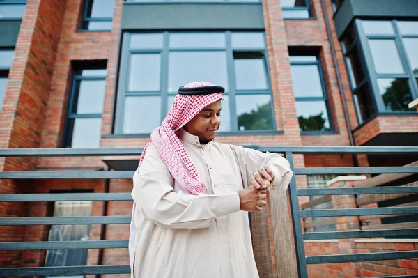 Orta Doğu Arap adam modern bina onun altın saatler seyir karşı sokağında poz verdi.