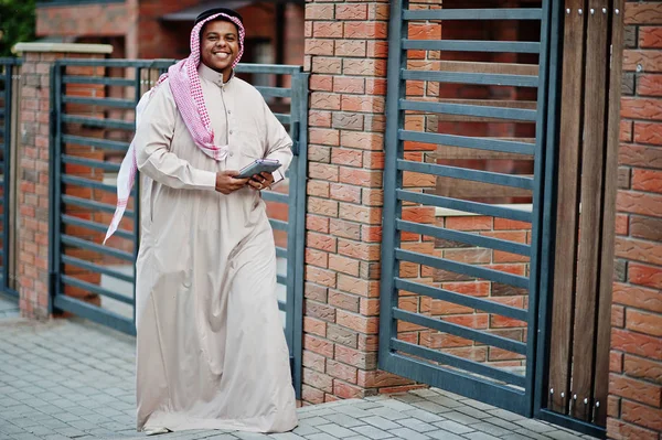 Orta Doğu Arap adam elinde tablet ile modern bina karşı sokağında poz verdi.