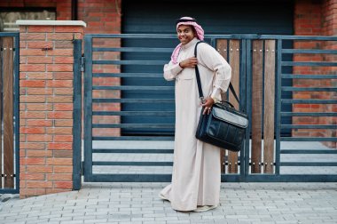 Orta Doğu Arap iş adamı siyah çanta ile modern bina karşı sokağında poz verdi.