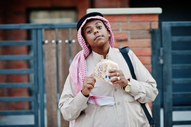 Orta Doğu Arap iş adamı siyah çanta ve euro paralar ile modern bina karşı sokağında poz verdi.