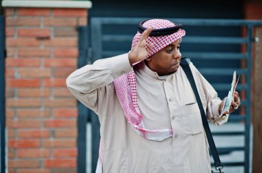 Orta Doğu Arap iş adamı siyah çanta ve euro paralar ile modern bina karşı sokağında poz verdi.