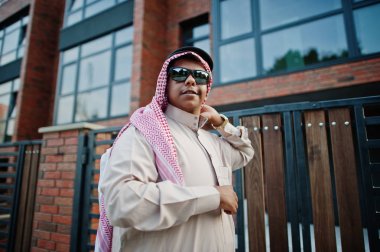 Güneş gözlüğü ile modern bina karşı sokağında poz Orta Doğu Arap iş adamı.