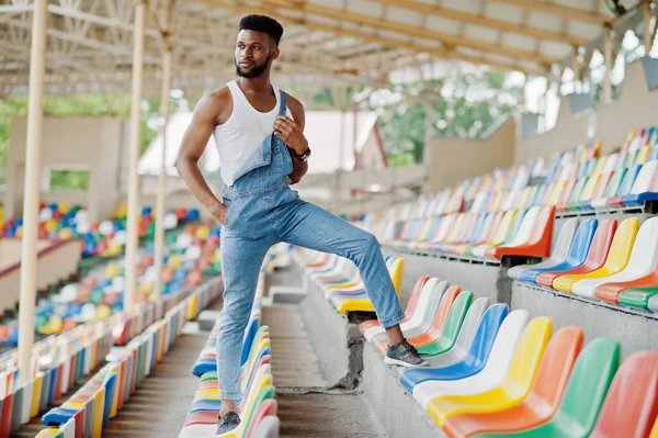 Knappe Afro Amerikaanse Man Jeans Jumpsuits Gesteld Gekleurde Stoelen Stadium — Stockfoto