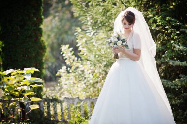 Güzel düğün buket onun elinde açık havada tutan bir nazik muhteşem gelin portresi.