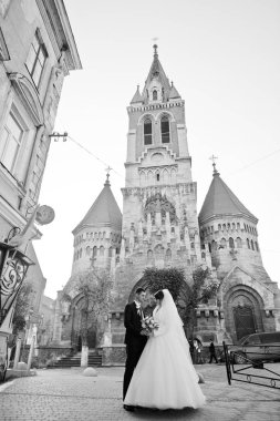 Yeni evli çift şehrin eski kilisede yanında güzel bir sonbahar düğün gününde poz.