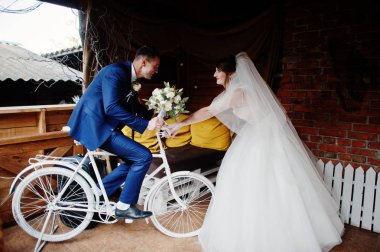 Bisiklet ve onu binmekten durdurmaya gelin oturan damat. 