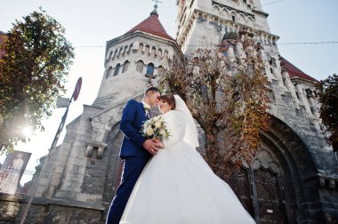 Yeni evli çift şehrin eski kilisede yanında güzel bir sonbahar düğün gününde poz.