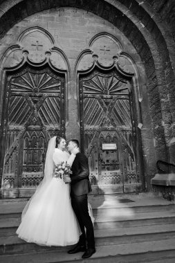 Eski bir şehirde eski kapılar tarafından düğün gününde poz romantik yeni evli çift.