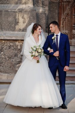 Eski bir şehirde eski kapılar tarafından düğün gününde poz romantik yeni evli çift.