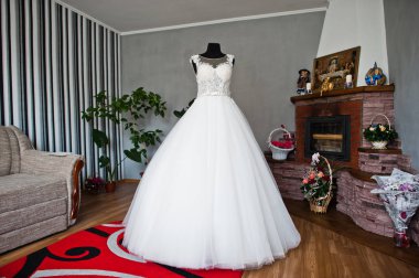 Odanın ortasında zarif beyaz gelinlik..