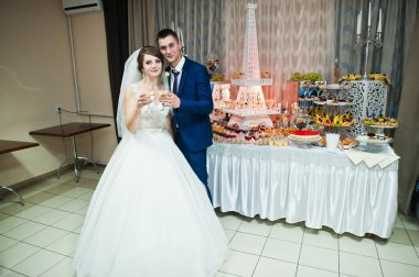 Muhteşem düğün çifti restoranda şarap bardakları ile poz.