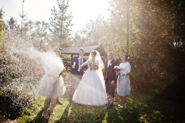 Nedime şişe şampanya düğün çifti ve sağdıç ile başka bir nedime yanında açılması.