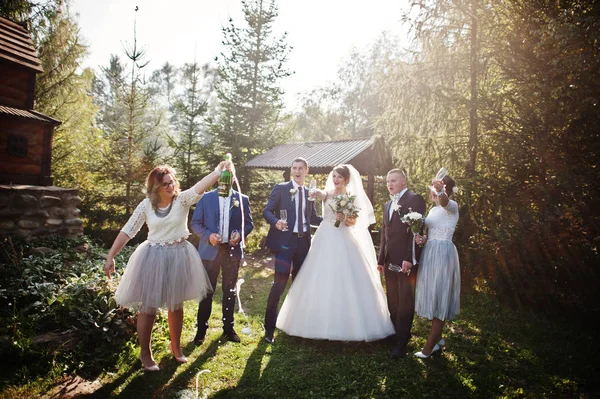 Подружка Невесты Открывает Бутылку Шампанского Рядом Свадебной Парой Одной Подружкой — стоковое фото