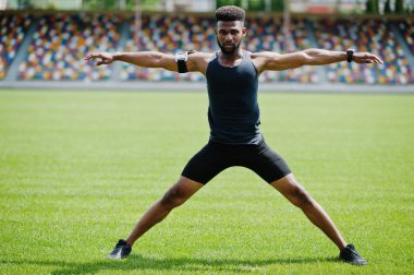 Spor stadyumunda germe egzersiz yaparak Afro-Amerikan erkek atlet.