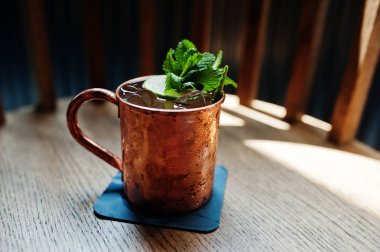 Buz, nane ve limon bar masa üzerinde bronz Kupası ile alkollü kokteyl.