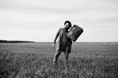 Gözlük, kahverengi ceket ve şapka çanta ile şık adam yeşil sahada poz verdi..