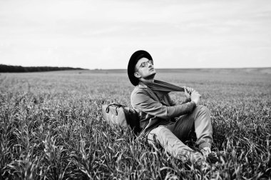 Gözlük, kahverengi ceket ve şapka çanta ile şık adam yeşil sahada poz verdi..