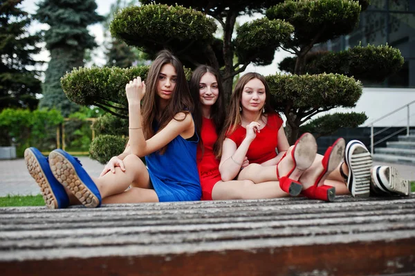 三名少女穿着蓝色和红色连衣裙摆在户外 — 图库照片