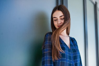 Büyük pencereler karşı mavi Kareli gömlekli genç esmer kız portresi.