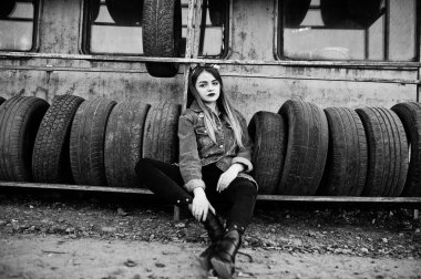 Lastik uygun bölgede kot ceket ve baş fularlı genç hippi kız.