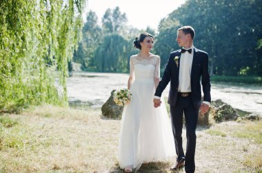 Gözlerinizi nehir kıyısında bakarak ve iki düğün yürüyor.