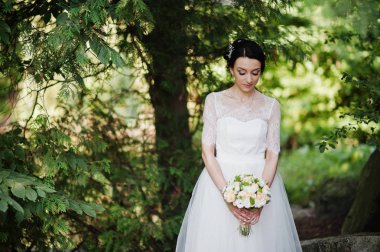 Çarpıcı bir genç gelin holidng portresi ormandaki onu buket.