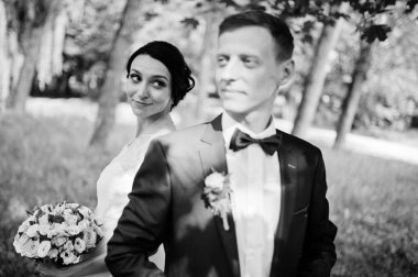 Yakın çekim portre çekici bir gelinin kocası parkta bakarak. Siyah ve beyaz fotoğraf.