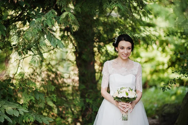 Çarpıcı bir genç gelin holidng portresi ormandaki onu buket.