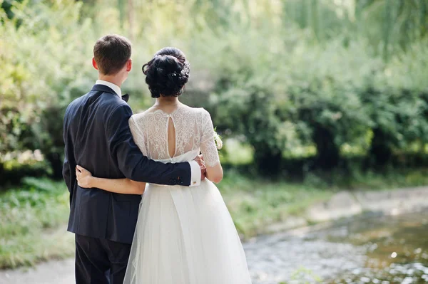 Фантастическая Свадебная Пара Обнимается Стоит Реки Открытом Воздухе — стоковое фото