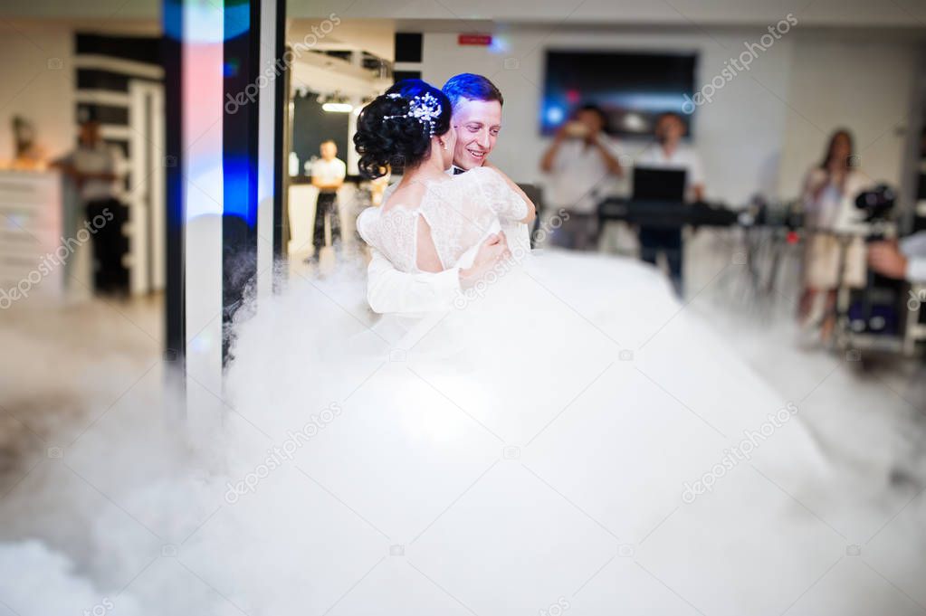 Romantic newly married couple performing their first dance in the restaurant with heavy smoke.