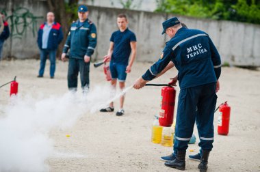 Hai, Ukrayna - 10 Temmuz 2018: Öğretici nasıl yangın güvenliği ver, yangın söndürmek için. İtfaiyeci yangın söndürücü elinde tut. Alev koruma. Eğitim yönergeleri gösterme.