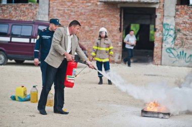 Hai, Ukrayna - 10 Temmuz 2018: Öğretici nasıl yangın güvenliği ver, yangın söndürmek için. İtfaiyeci yangın söndürücü elinde tut. Alev koruma. Eğitim yönergeleri gösterme.