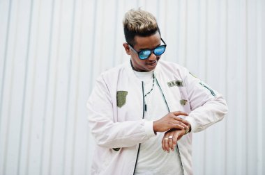 Şık hipster Arap adam adam sokakta açık poz verdi. Stil rap şarkıcısı çelik duvara.